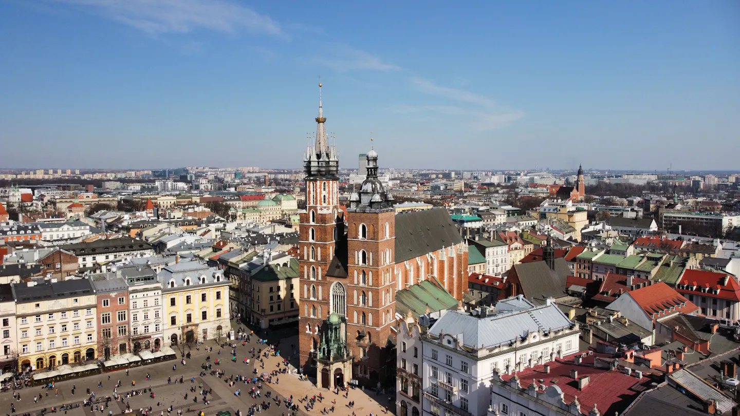 Aerial view over Kraków's old town, with the twin brick towers of St Mary's Basilica rising above the Main Market Square