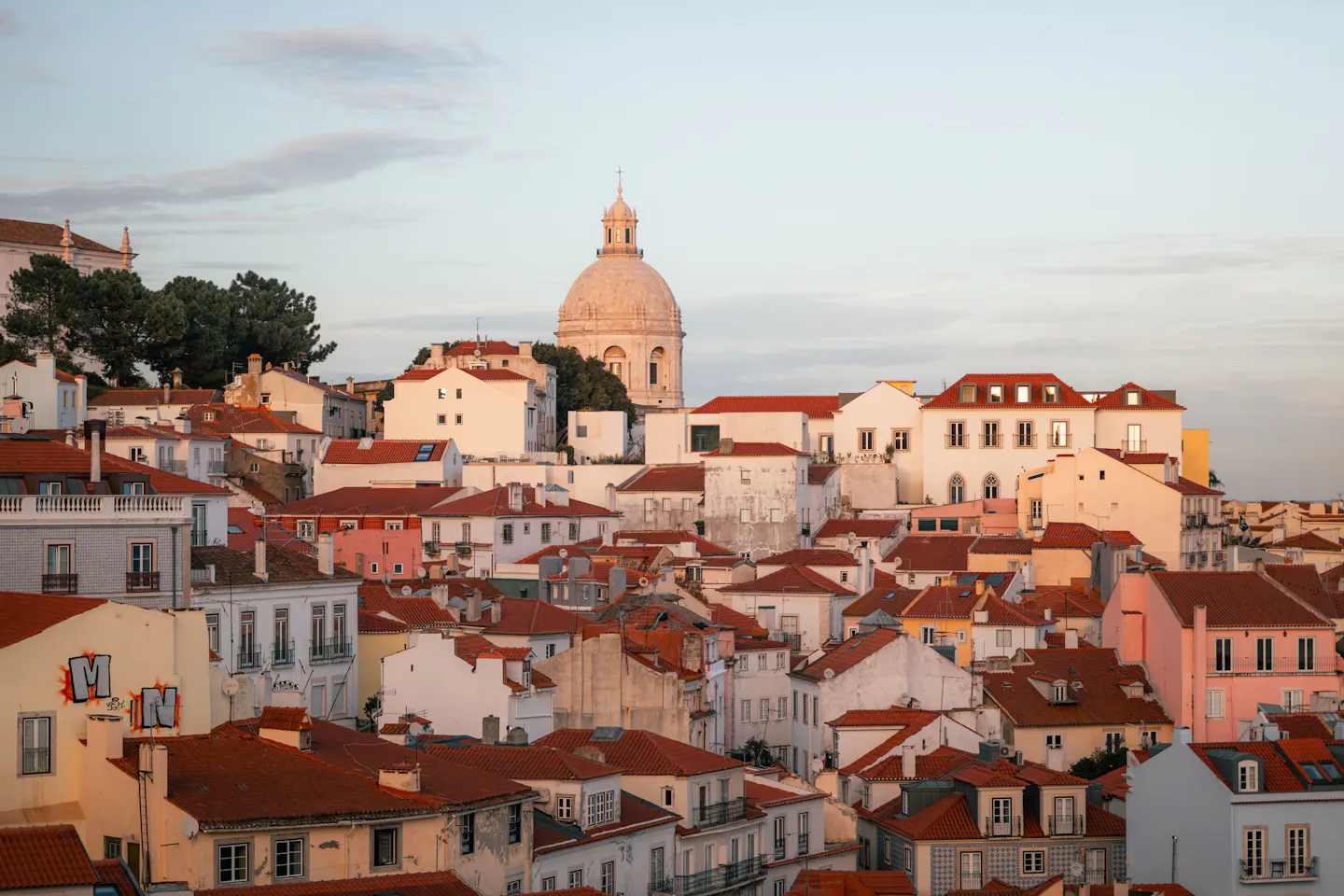 The rooftops of Alfama in Lisbon and the dome of the National Pantheon in pink evening light