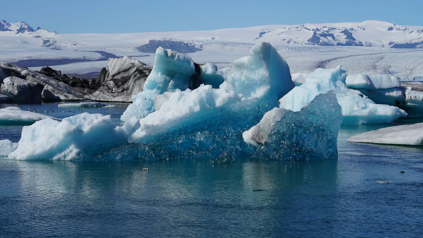 Jökulsárlón glacier lagoon on Iceland’s South Coast, with blue icebergs before snow-covered mountains