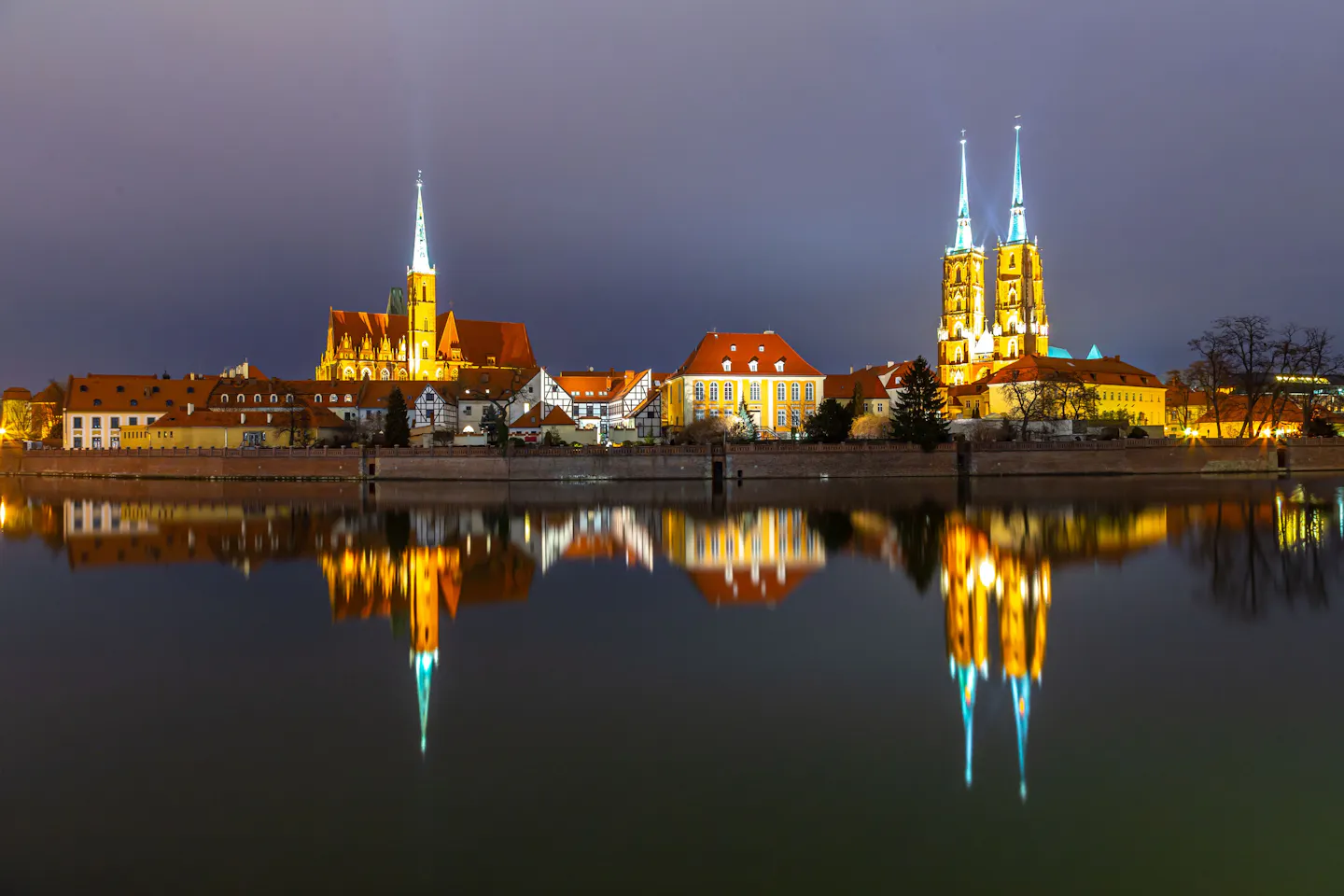 Wrocław Cathedral lit up beside the Oder at night