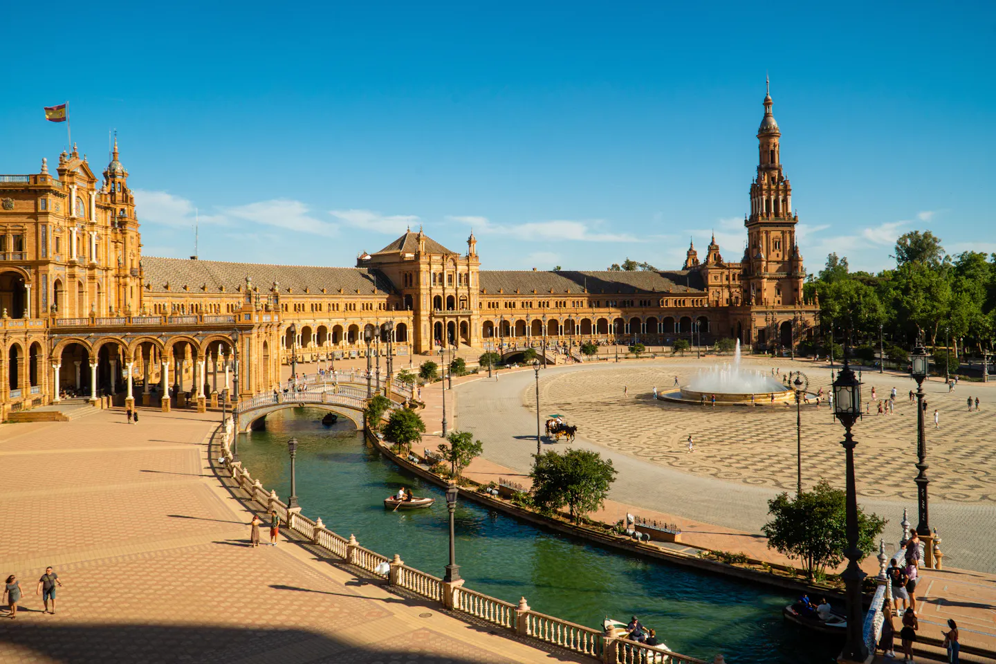 The curved arcades and canal of Plaza de Espana in Seville in golden evening light