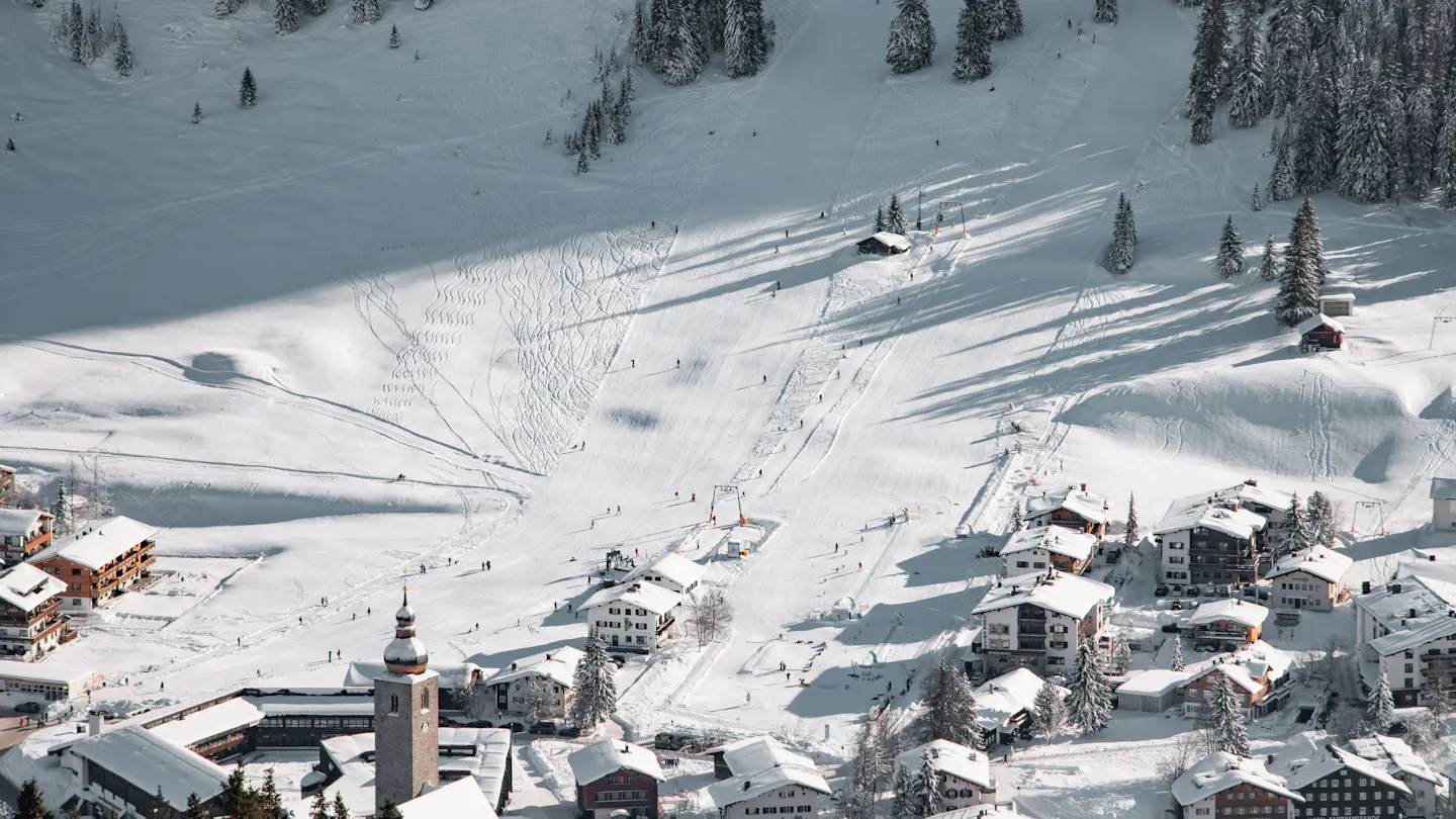 Lech am Arlberg in winter, with its church tower among snow-covered chalets and ski slopes
