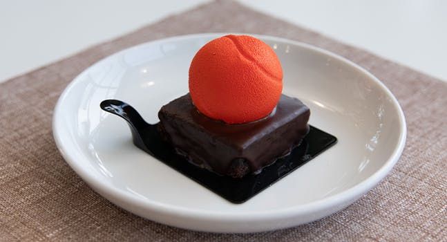 Orange Smash: Sfera di bavarese alla vaniglia tahiti con cuore al limone di Sorrento, fragole e menta su crumble croccante