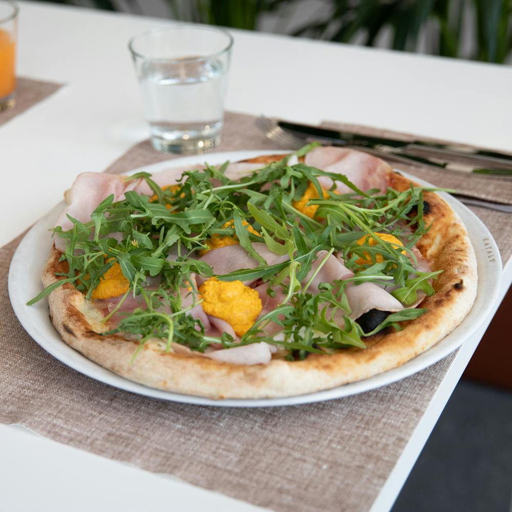Drop Shot Pizza: pizza con mozzarella fiordilatte, prosciutto cotto Veroni alle erbe, rucola e hummus di ceci e carote