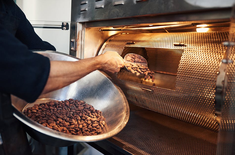 Adding cocoa beans to a roaster