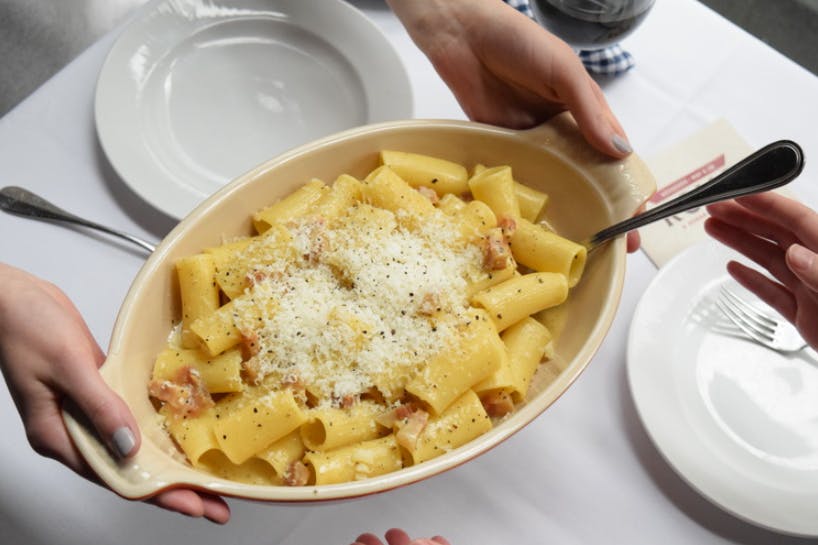 Passing a bowl of Paccheri pasta