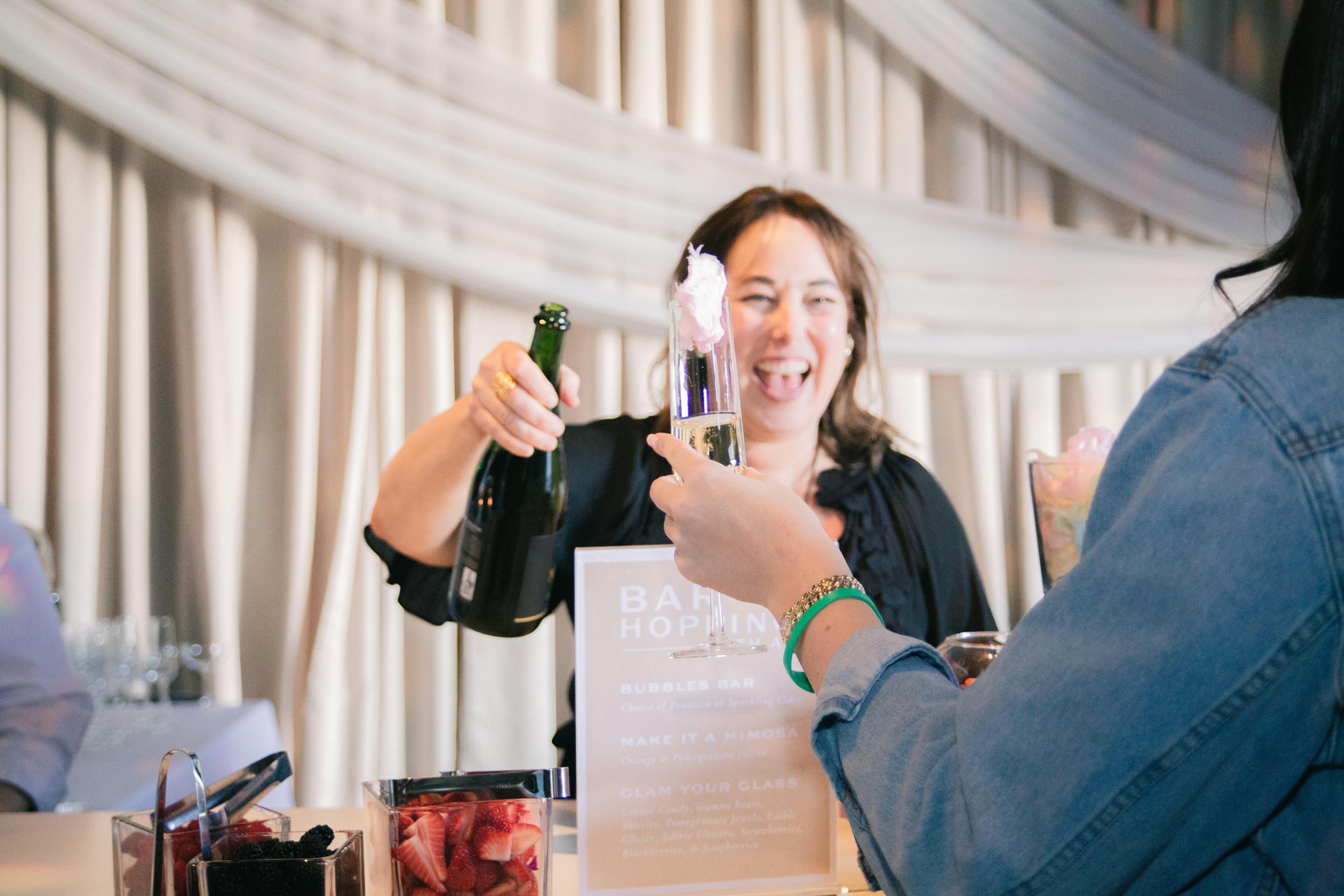 Renée pouring champagne
