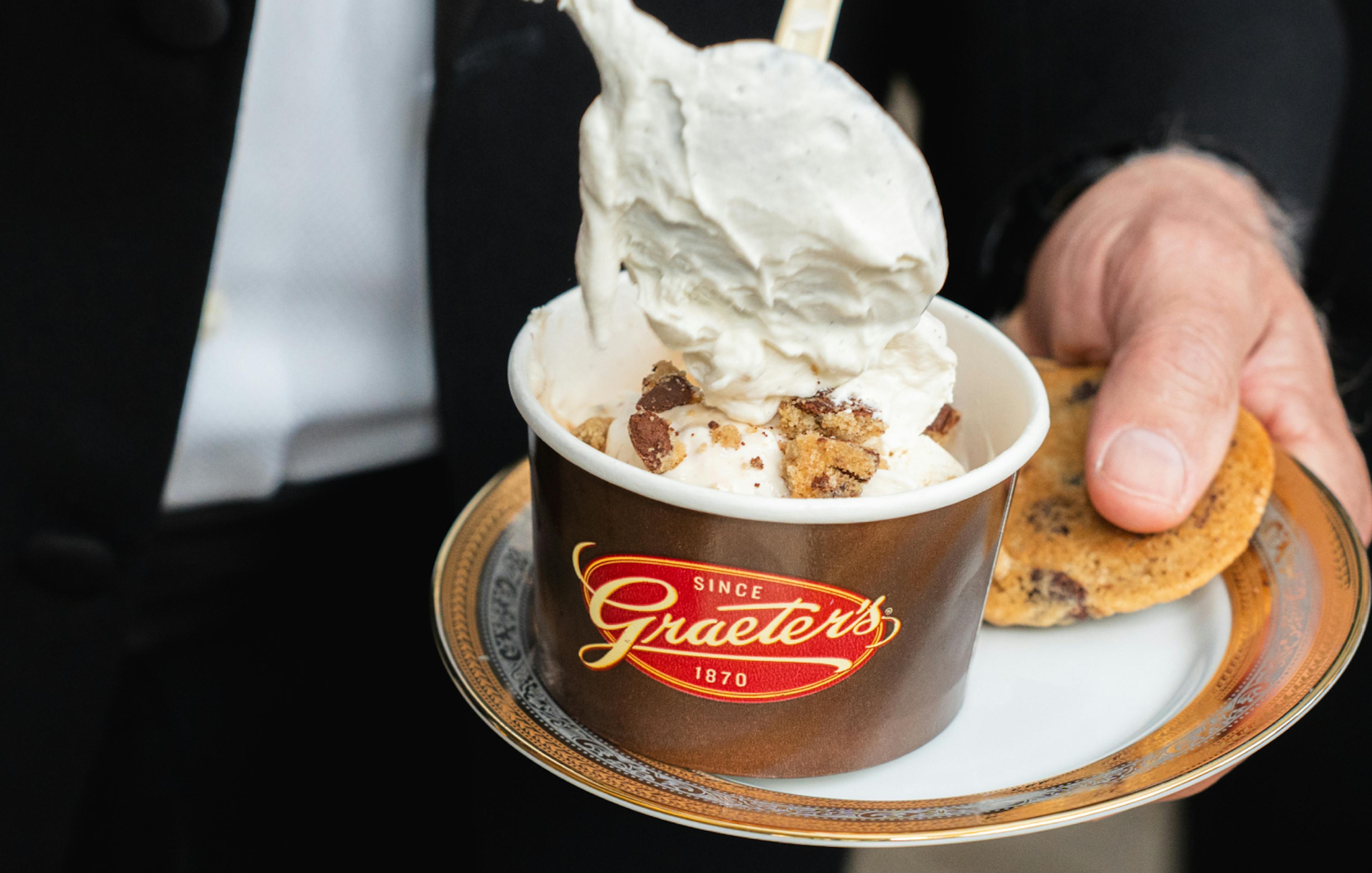 a guest tops their Graeter's ice cream with homemade whipped cream 