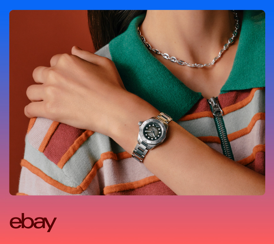 A close up image of someone wearing a watch and necklace. The person is cropped in and wearing a white, orange and red striped shirt with a green collar.