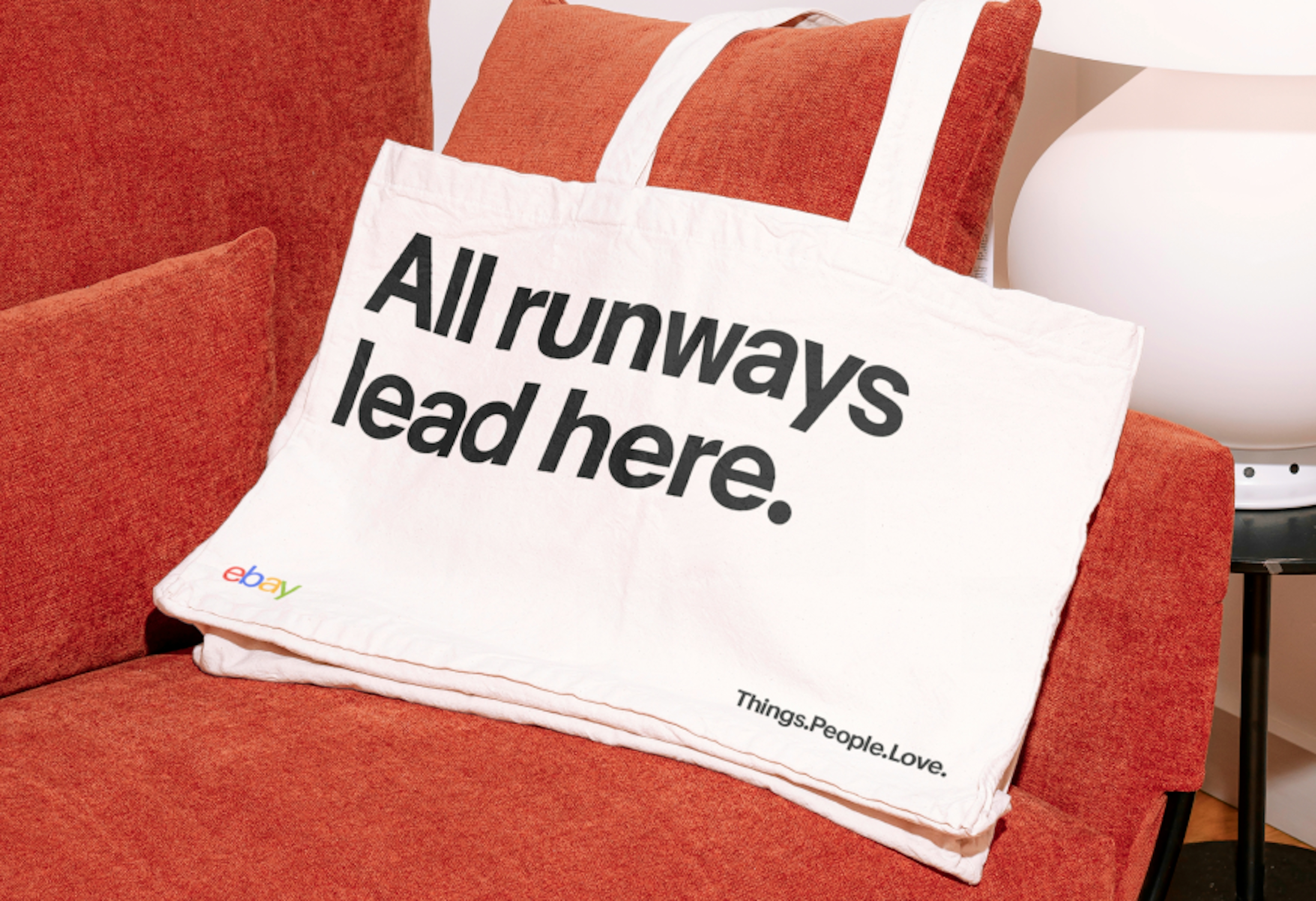 A tote bag with “All runways lead here.” typeset in a single size in Market Sans Bold.