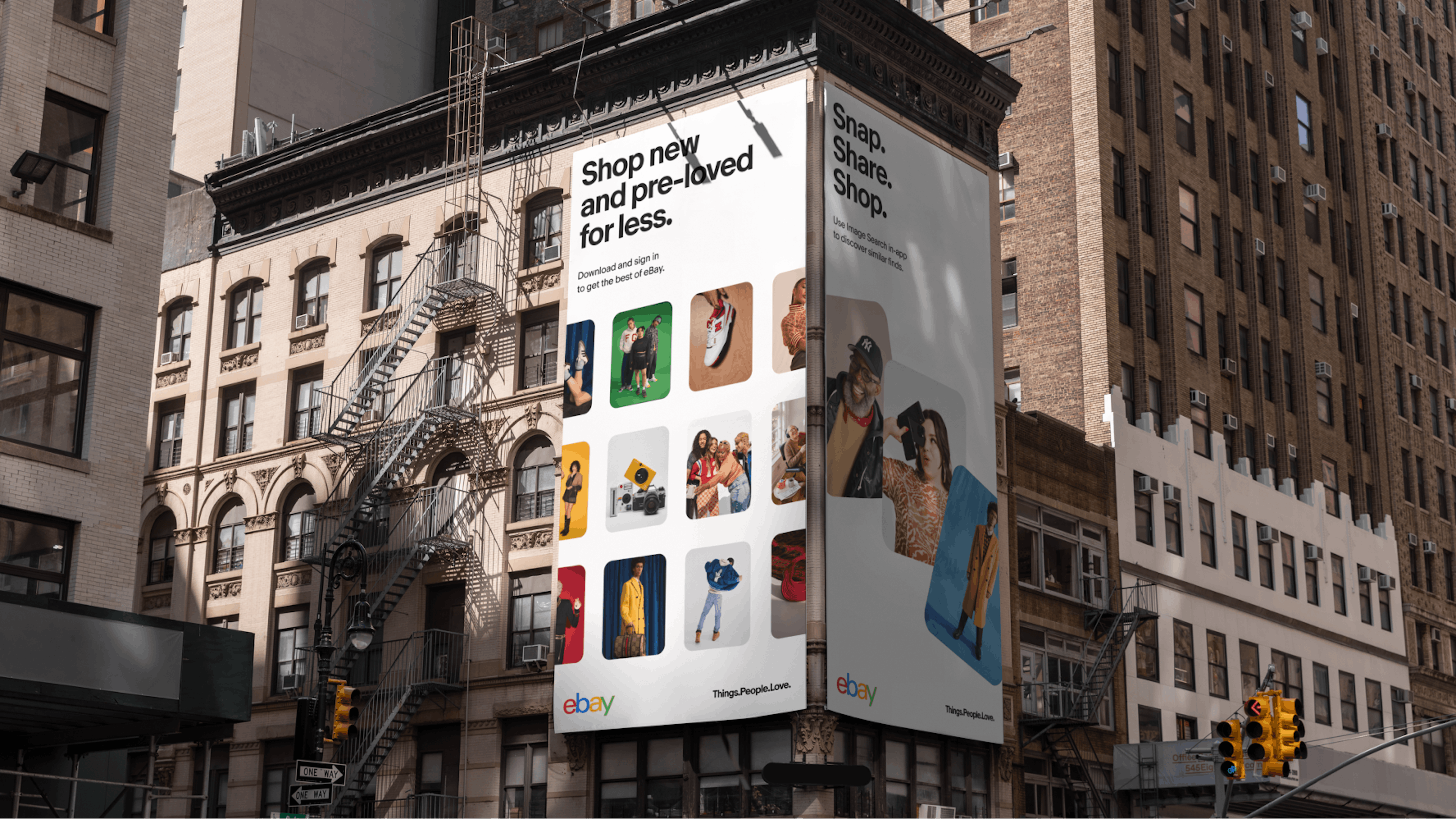 A large billboard advertisement on a building in a city promoting eBay with the text "Shop new and pre-loved for less" and "Snap. Share. Shop." The billboard features images of various products and people, encouraging viewers to download and sign in to the eBay app.