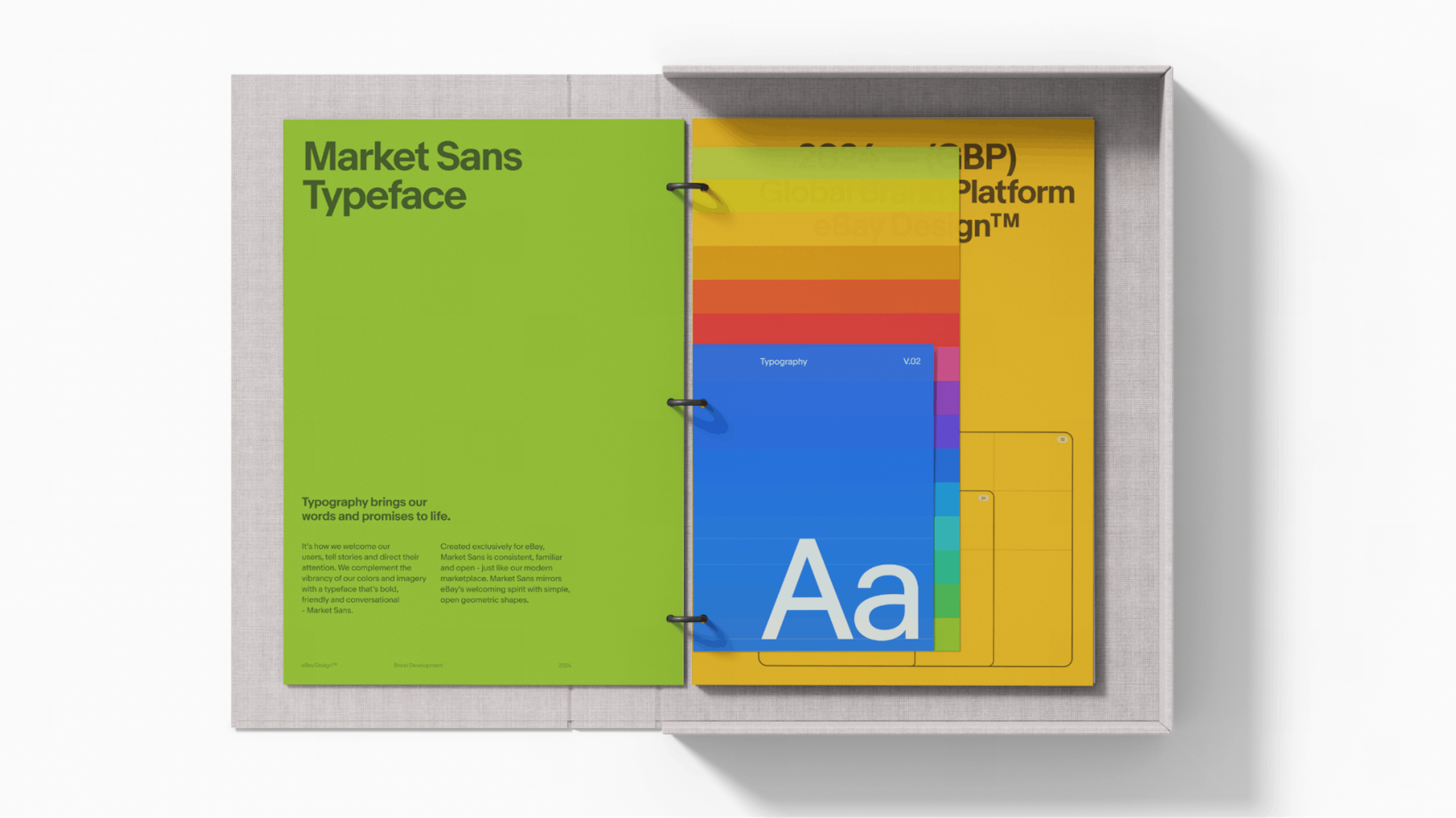 A colorful brand book highlighting the “Market Sans Typeface”. The book is open on a table and colorful pages with type are displayed.