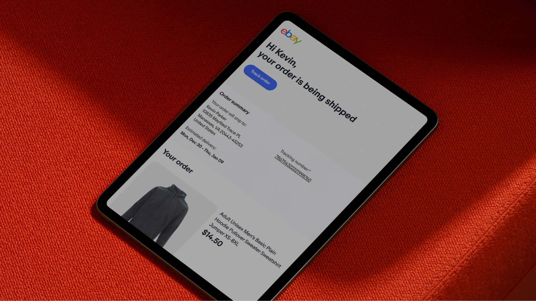 A tablet with a perA tablet on a vibrant red couch with a personalized eBay order confirmation email.er confirmation email.