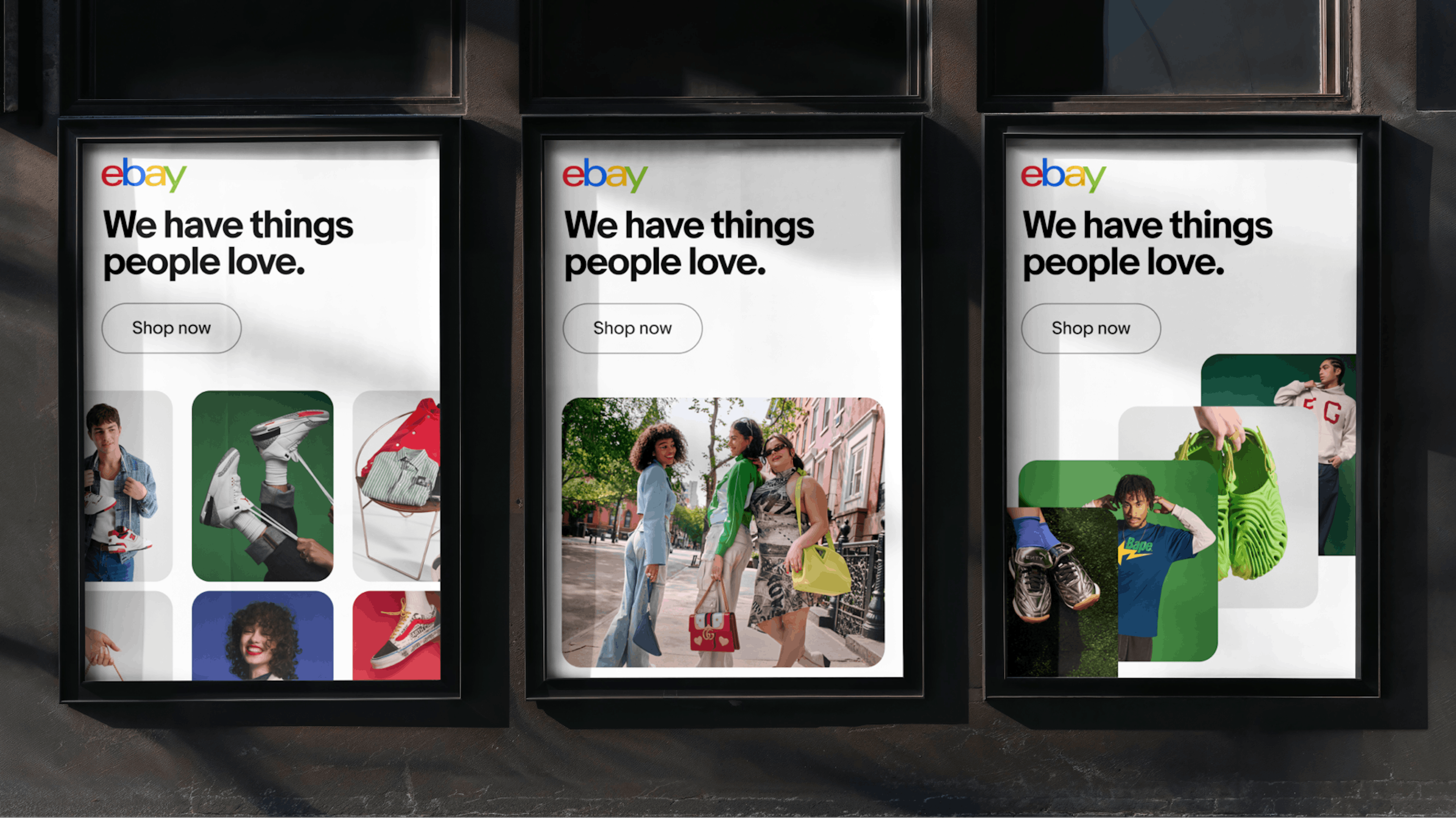 A series of printed posters inside glass frames on the side of a building. Each has the headline “We have things people love.” with a graphic button beneath it with “Shop now”. The images are a collection of sneaker, fashion, and streetwear in organic layouts across each.
