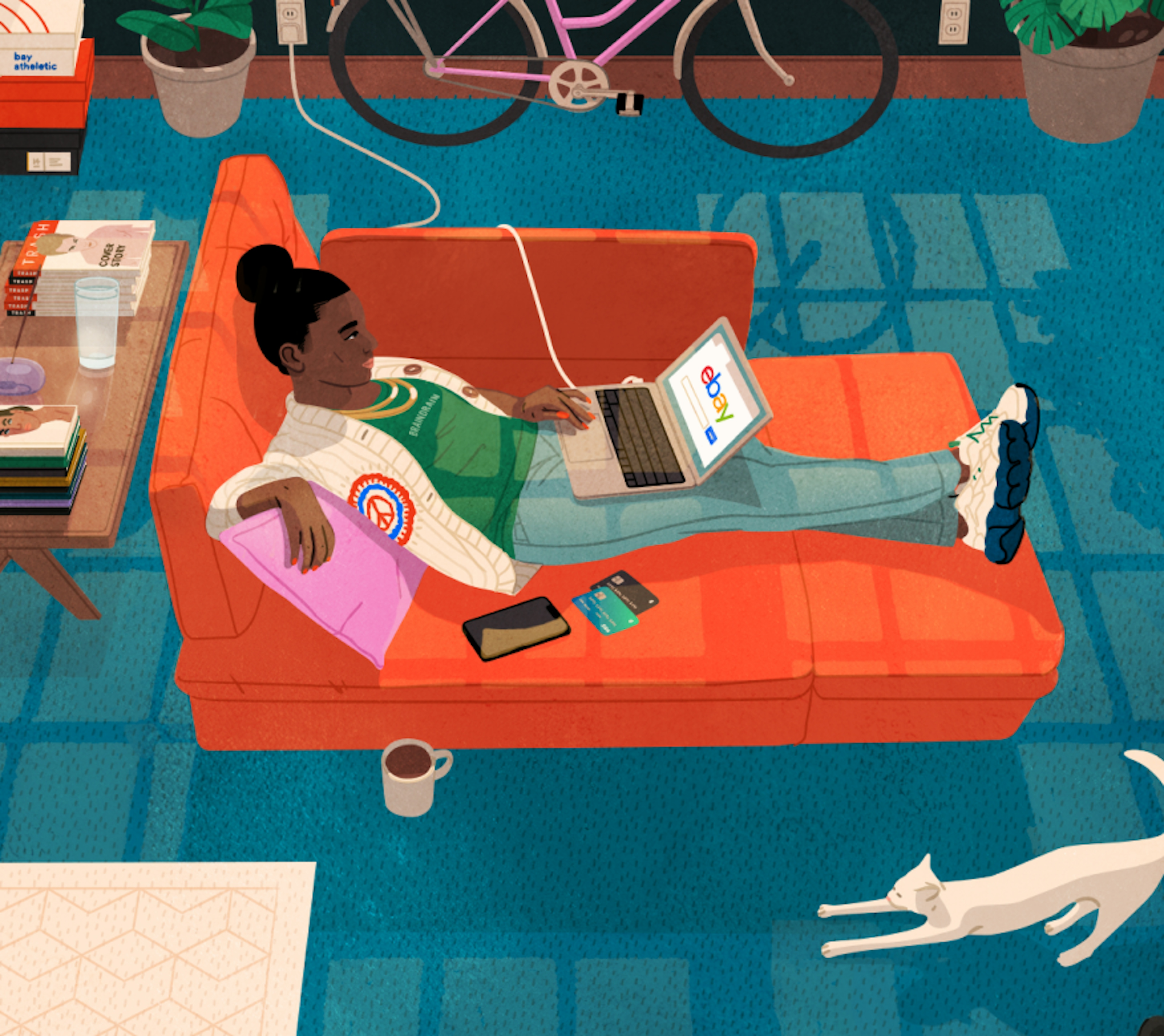 A person is lying on an orange sofa, using a laptop displaying the eBay website. The room includes a bicycle, plants, a white cat stretching on the floor, and a coffee table with books and a drink. There are shoe boxes in the corner and a poster on the wall in the background.
