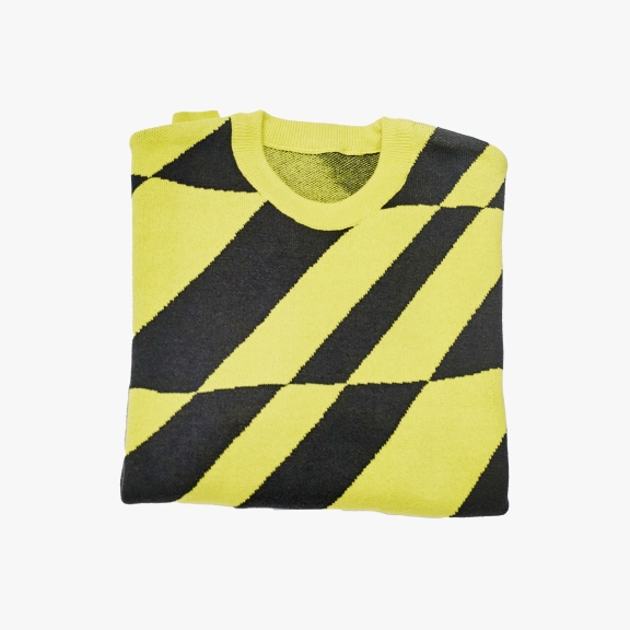 A folded sweater with a bright yellow and black diagonal stripe pattern without any shadow.