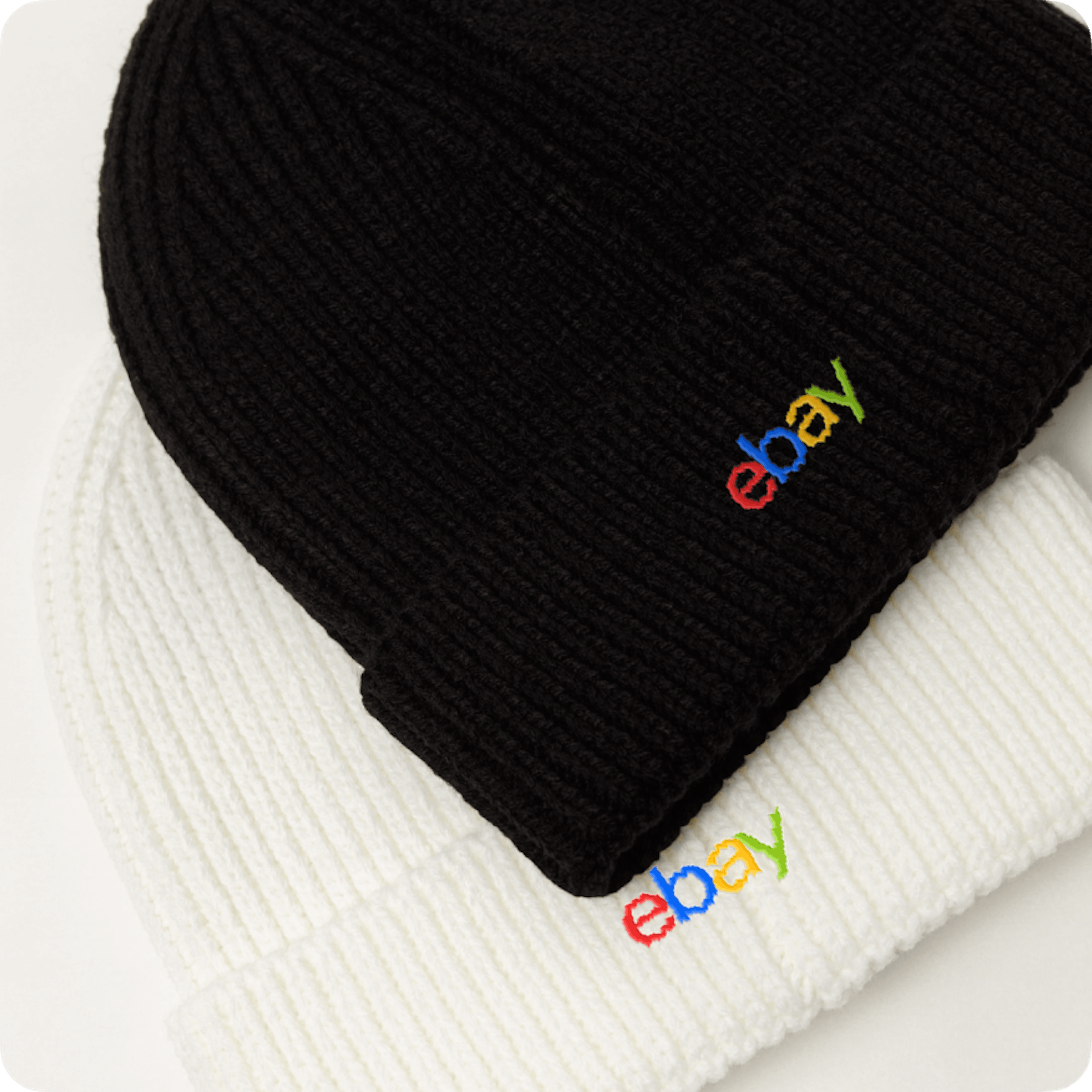 Black and white beanies with 4-color heritage logos embroidered on them.