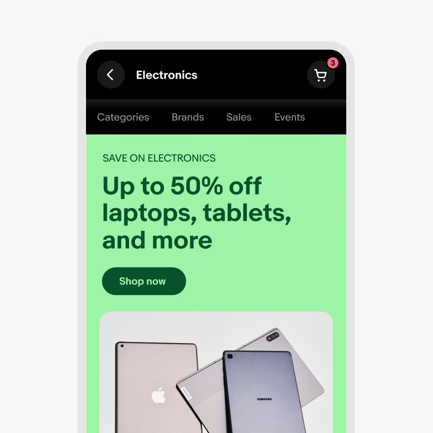A closeup of the eBay app in dark mode, with a light green banner with dark green text displaying various electronic tablets.