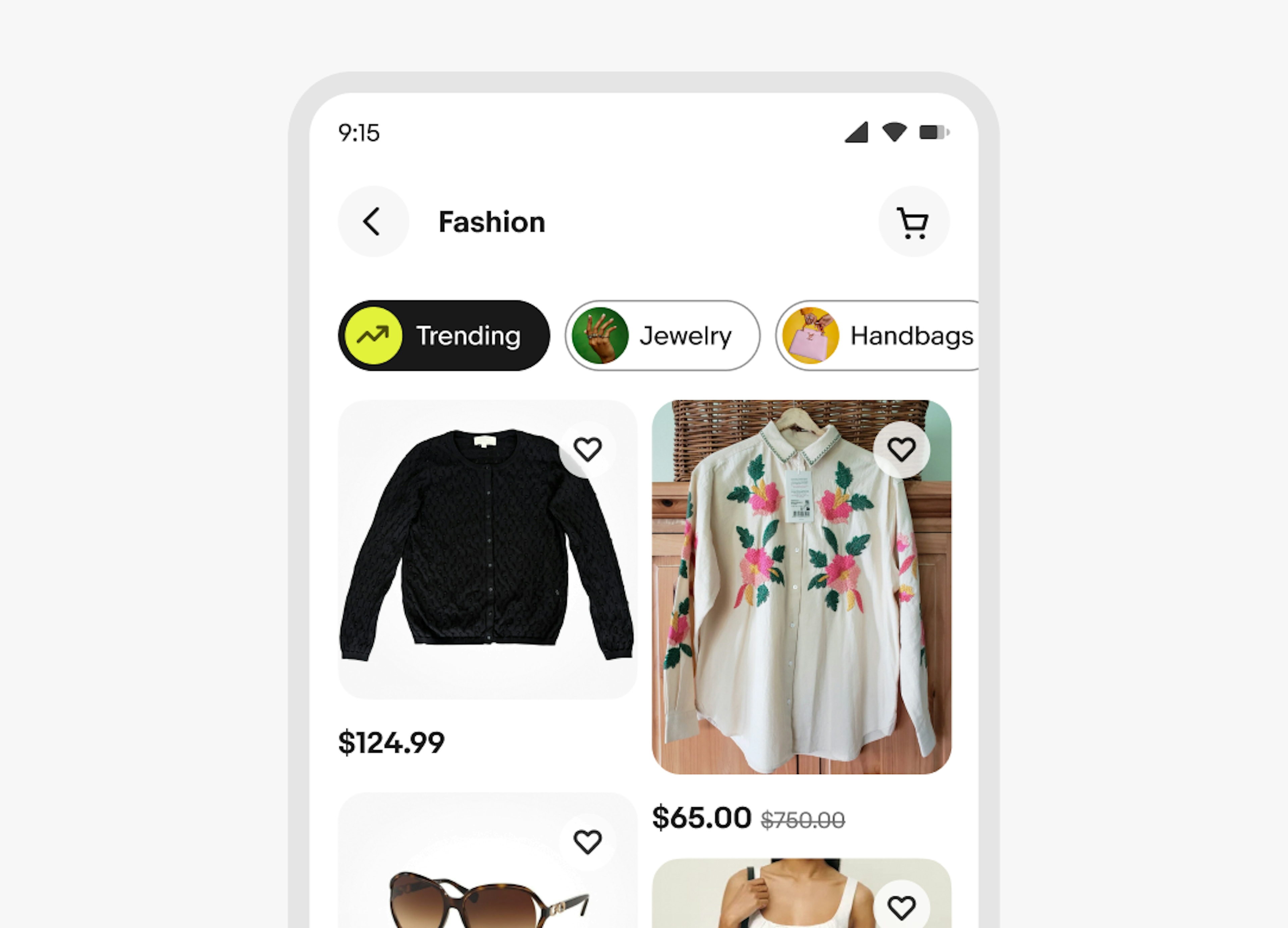 A fashion page with Discovery chips at the top, including Trending, Jewelry, and Handbags. Below, items like a pair of speakers, a denim jacket, headphones, and white athletic shorts are shown in a grid, each with a price and a heart icon for favoriting.