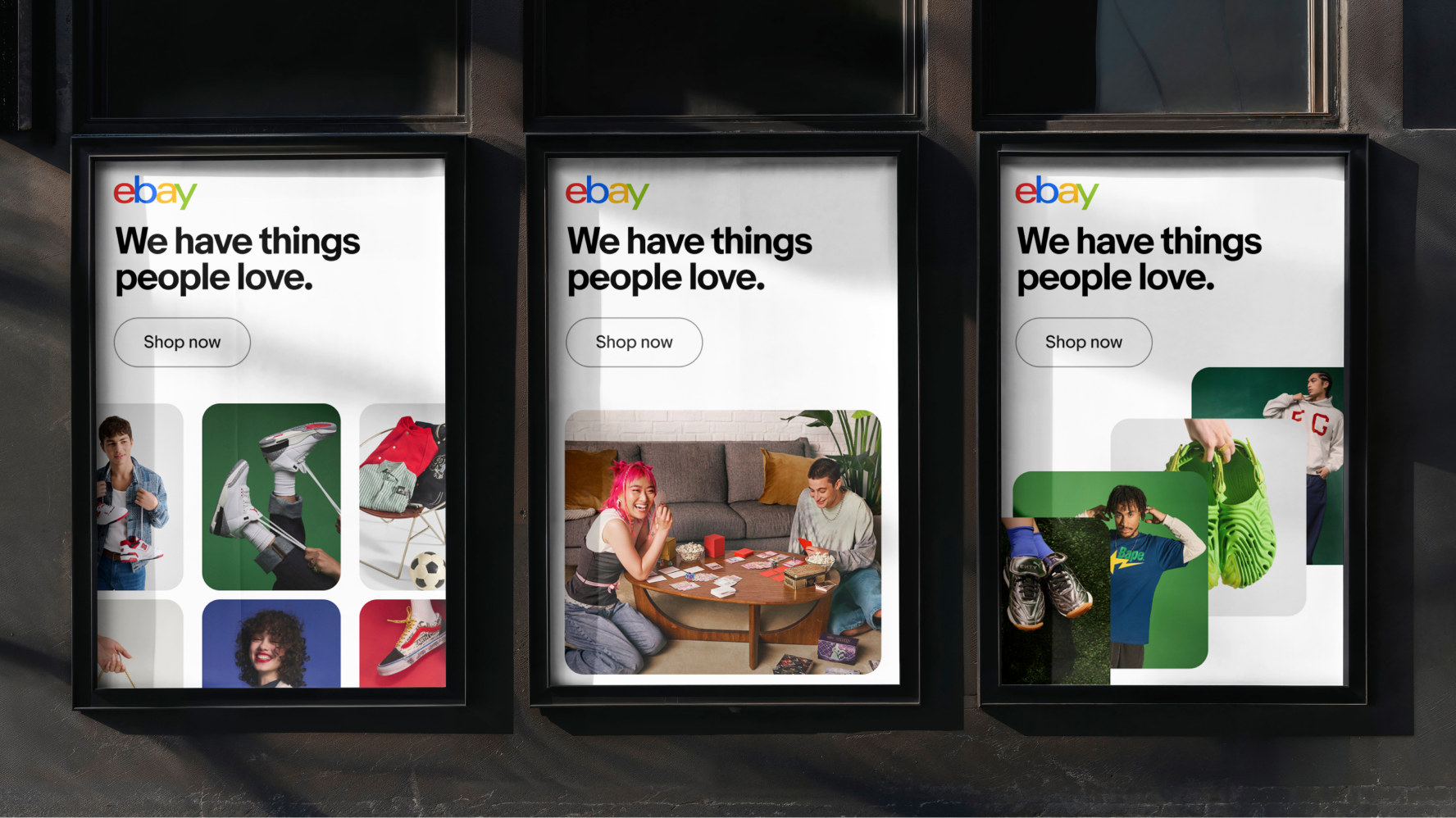 A series of printed posters inside glass frames on the side of a building. Each has the headline “We have things people love.” with a graphic button beneath it with “Shop now”. The images are a collection of sneaker, fashion, and streetwear in organic layouts across each.