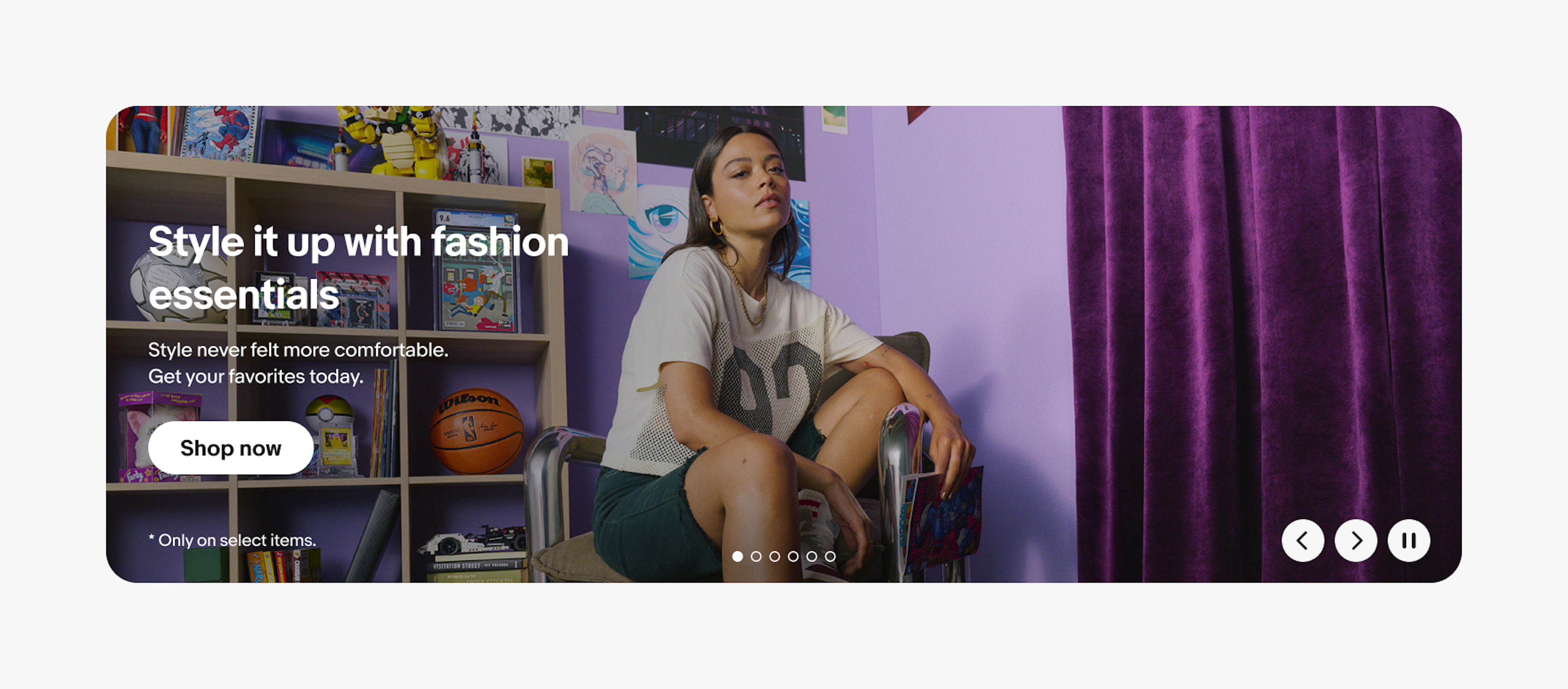 A website banner promoting fashion essentials, featuring the headline "Style it up with fashion essentials" beside a person seated in a colorful room filled with collectibles, with a "Shop now" button and carousel navigation controls.