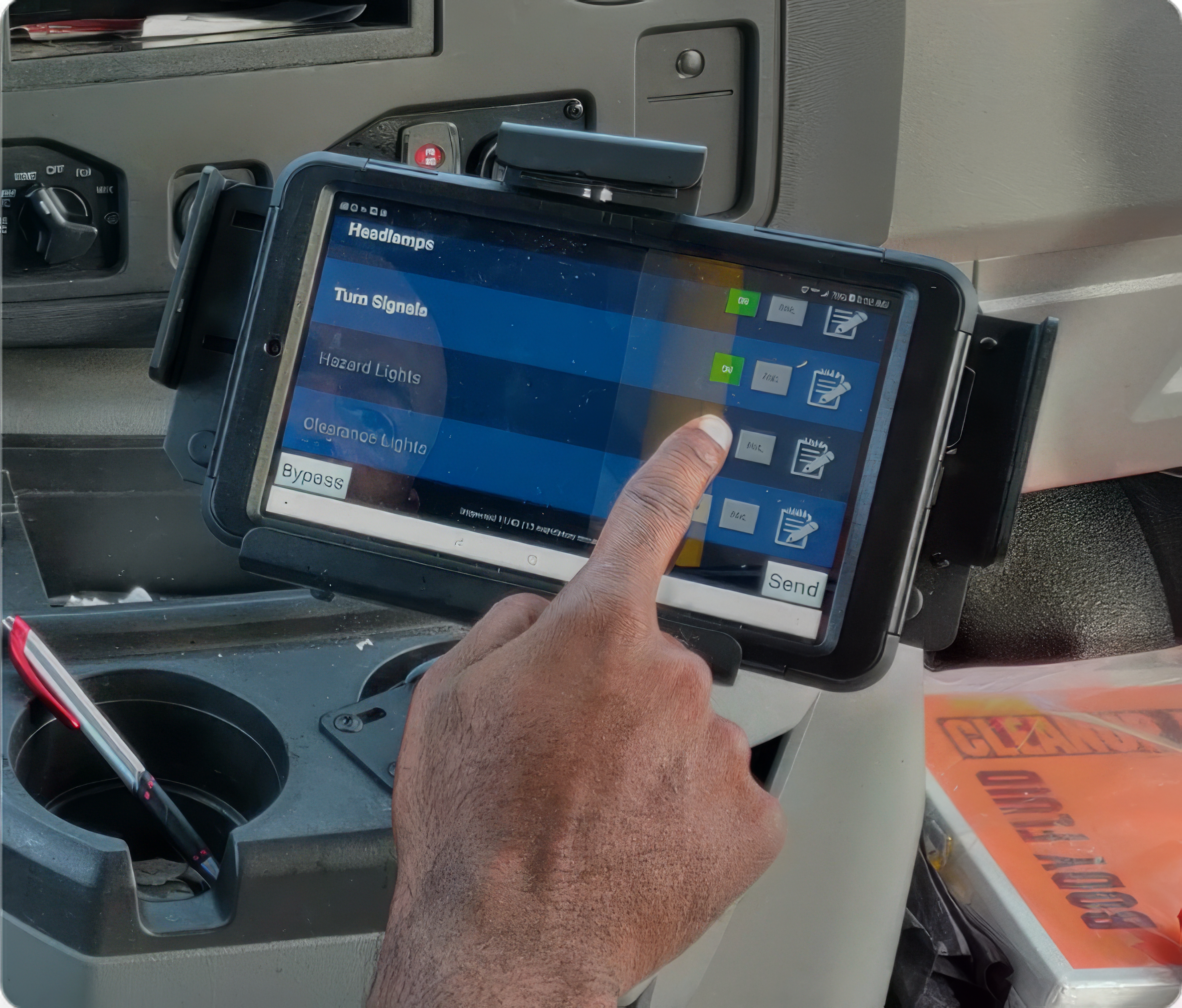 Driver uses a mounted tablet inside a vehicle to control operational settings, with on-screen buttons for lights and signals.