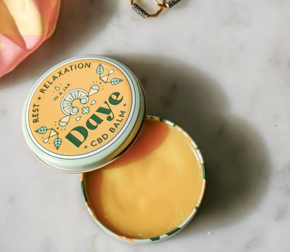 an open Daye rest and relaxation balm with the cream inside visible 