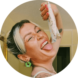 blond woman holds tampons with flushable wrappers next to her face