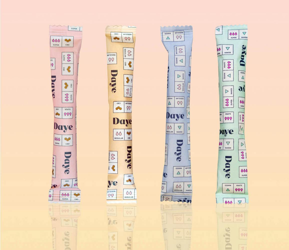 four organic, pesticide-free Daye tampons in pink, yellow, blue and green showing Nude and Pain-Relieving Tampons