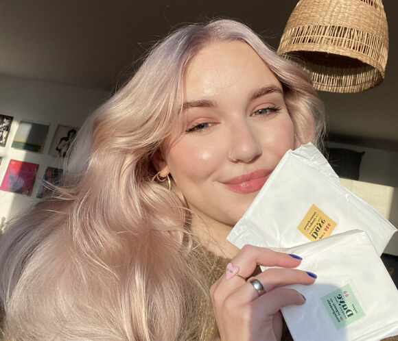 Happy female customer showing Daye's organic sustainable cotton pad