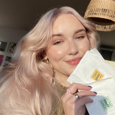 Щастлива клиентка, показваща органична устойчива памучна превръзка на Daye