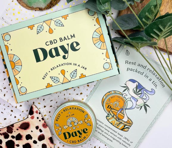 the Daye balm with the tin and the paper packaging 