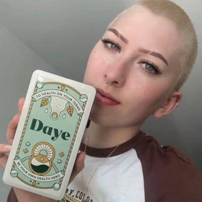 Момиче показва своята подаръчна кутия с органични CBD тампони на Daye