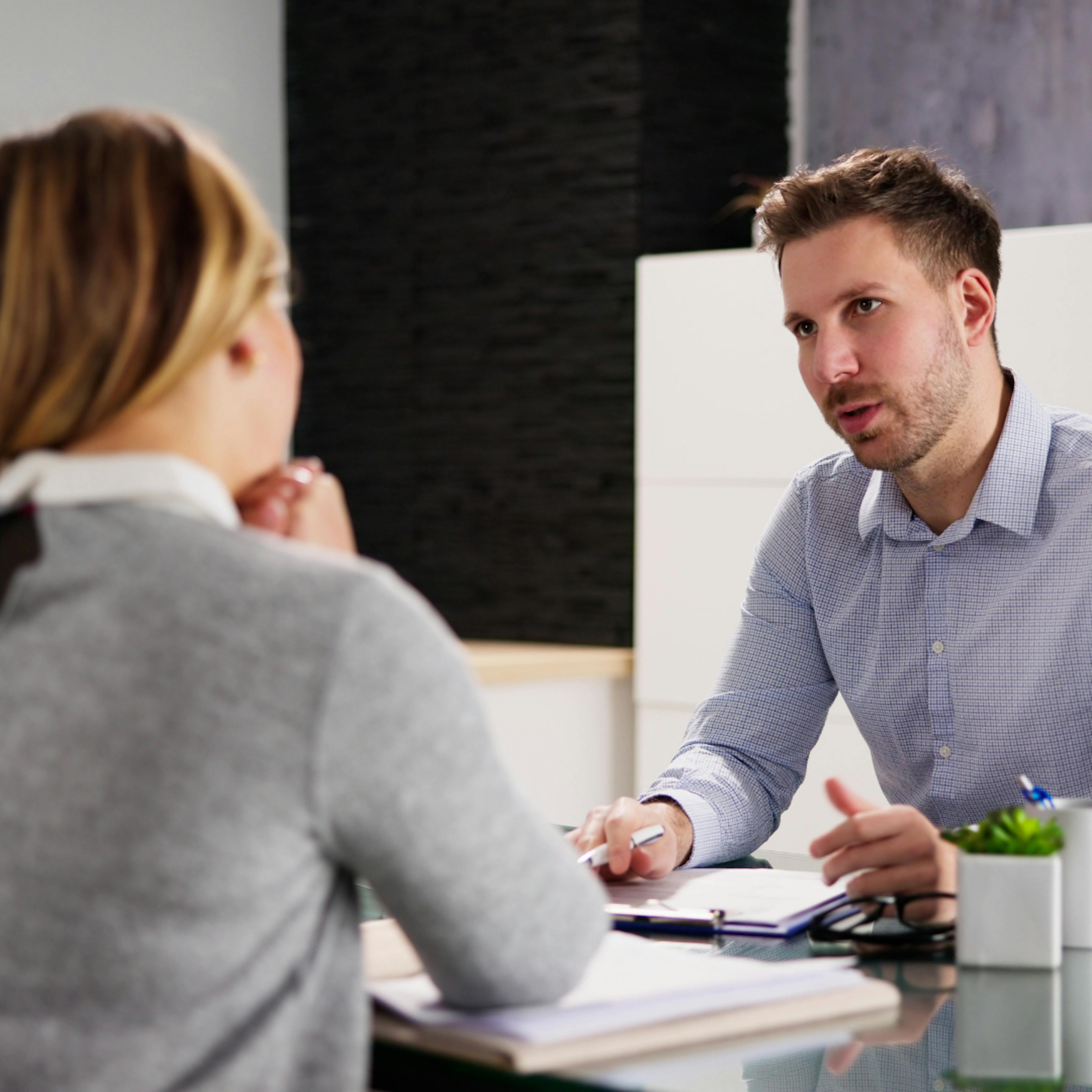 Two people sitting across a table talking