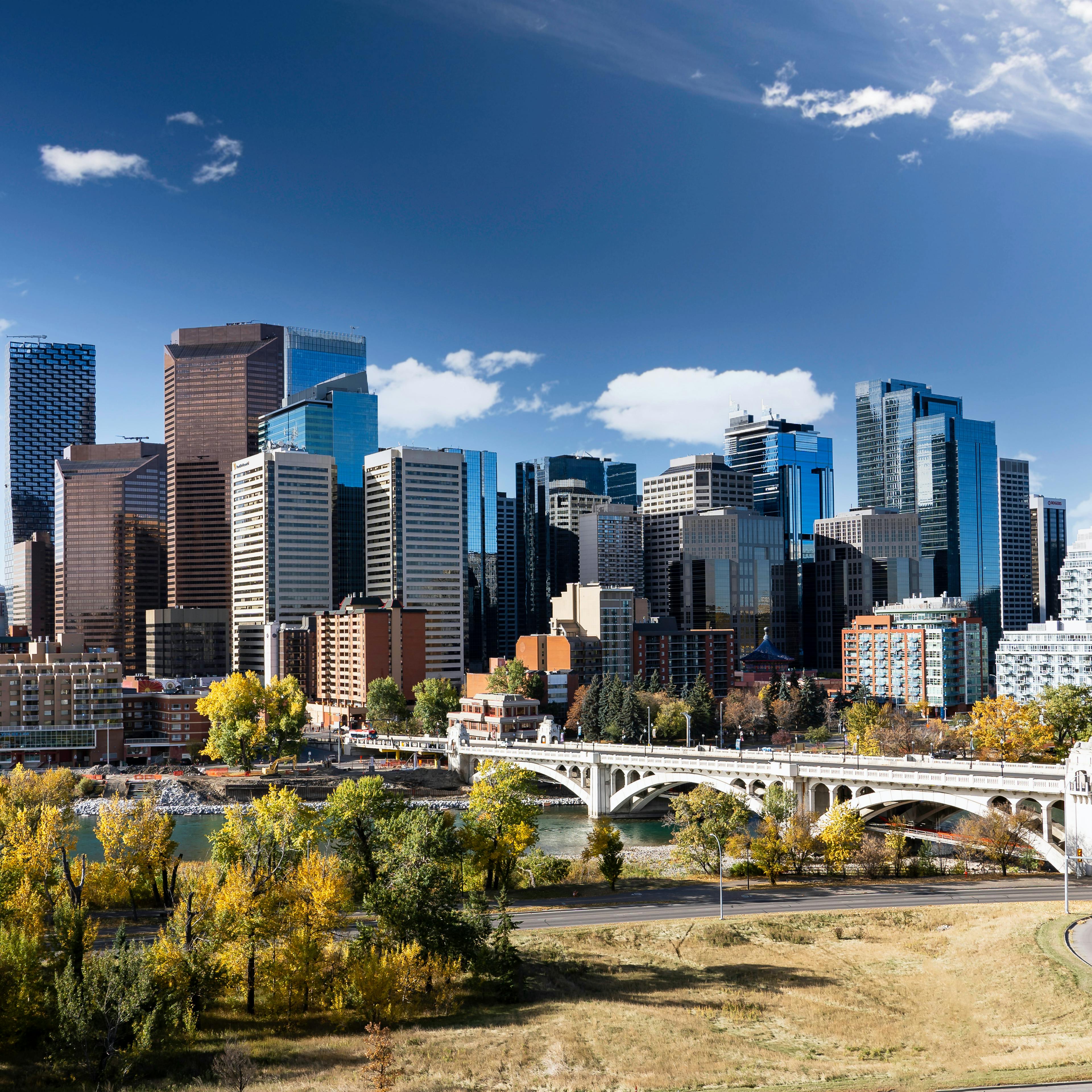 Downtown Calgary skyline in fall colours with office buildings and popular landmarks including the Center street Bridge and Riley park in Alberta