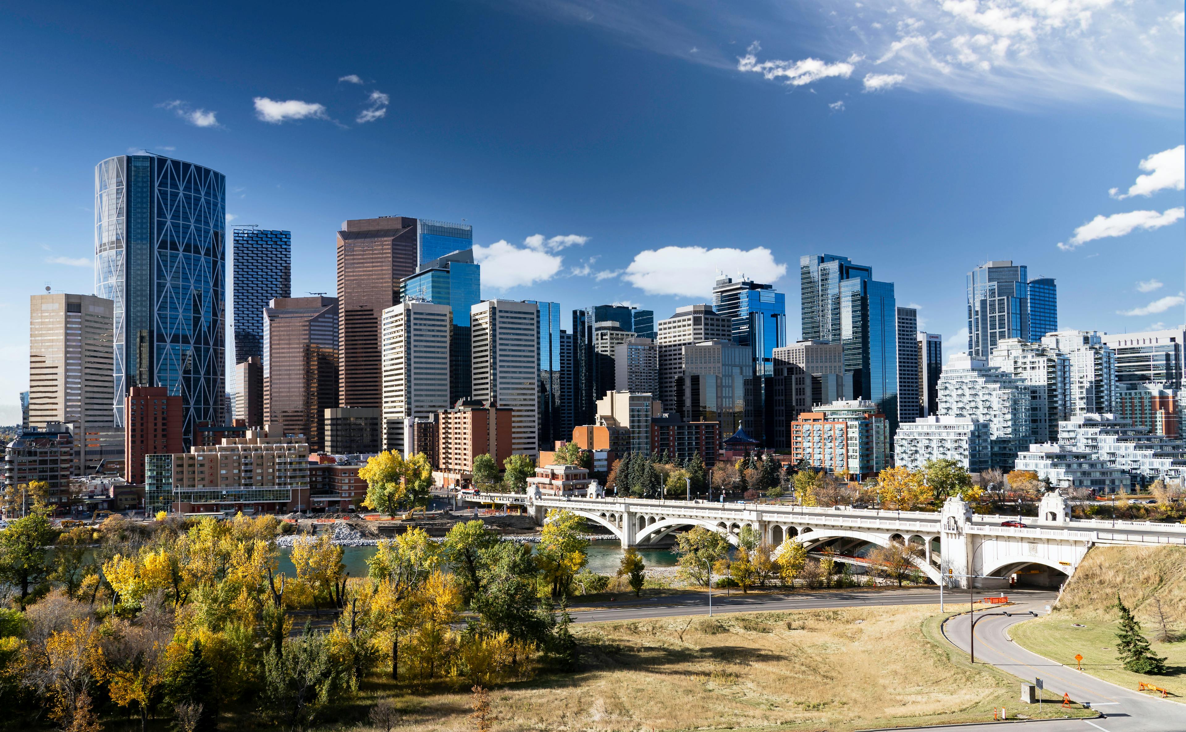 Downtown Calgary skyline in fall colours with office buildings and popular landmarks including the Center street Bridge and Riley park in Alberta