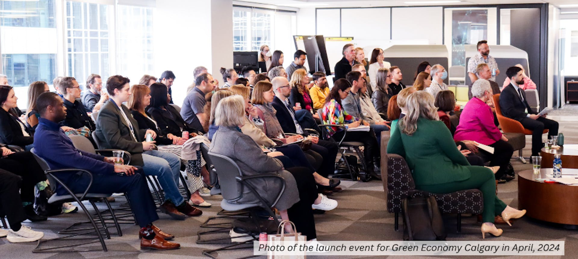 crowd of people in chairs looking at a stage