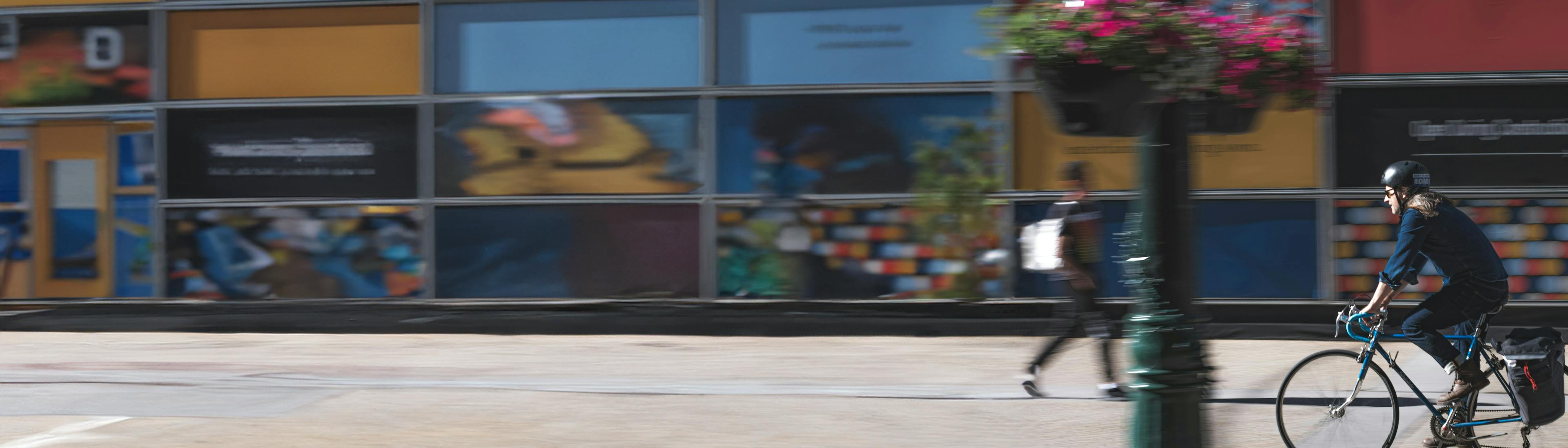 Person biking on a city sidewalk