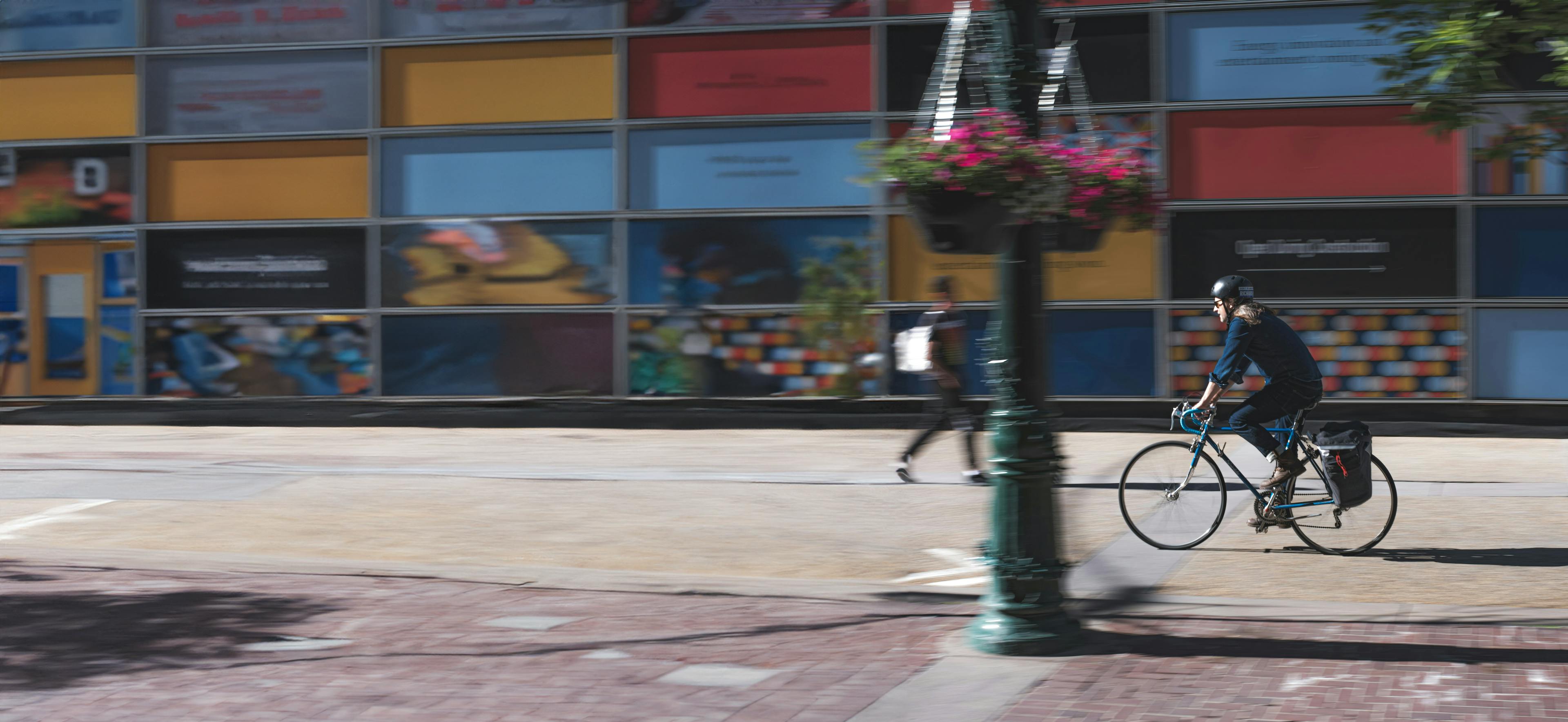 Person biking on a city sidewalk