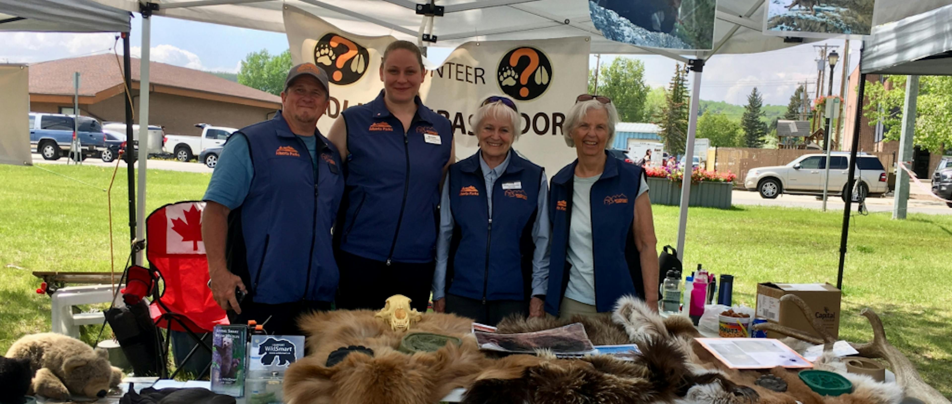 Four people standing a booth for Biosphere Institute of the Bow Valley