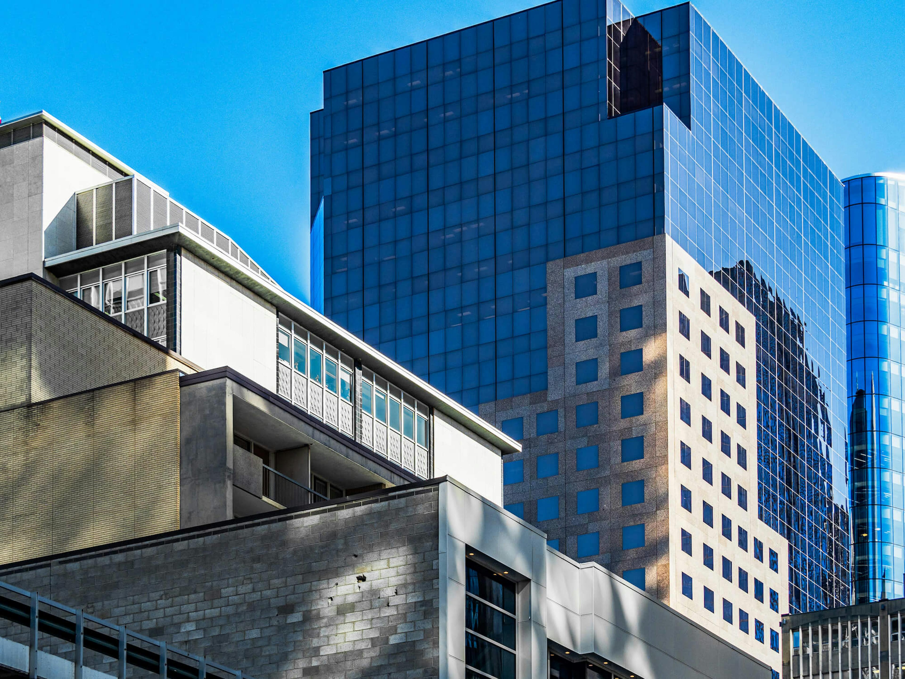 A tall blue skyscraper in a city