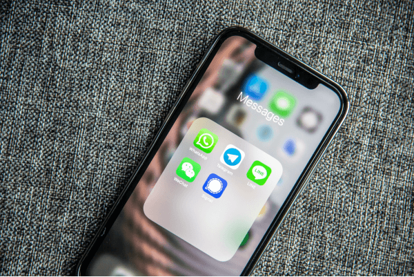 iPhone with screen on Messages box, Telegram, WeChat, WhatsApp, and Line apps are on screen
