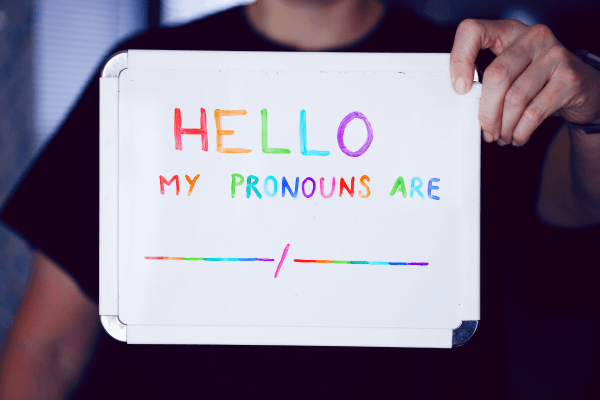 Colorful placard that says: HELLO my pronouns are _/_