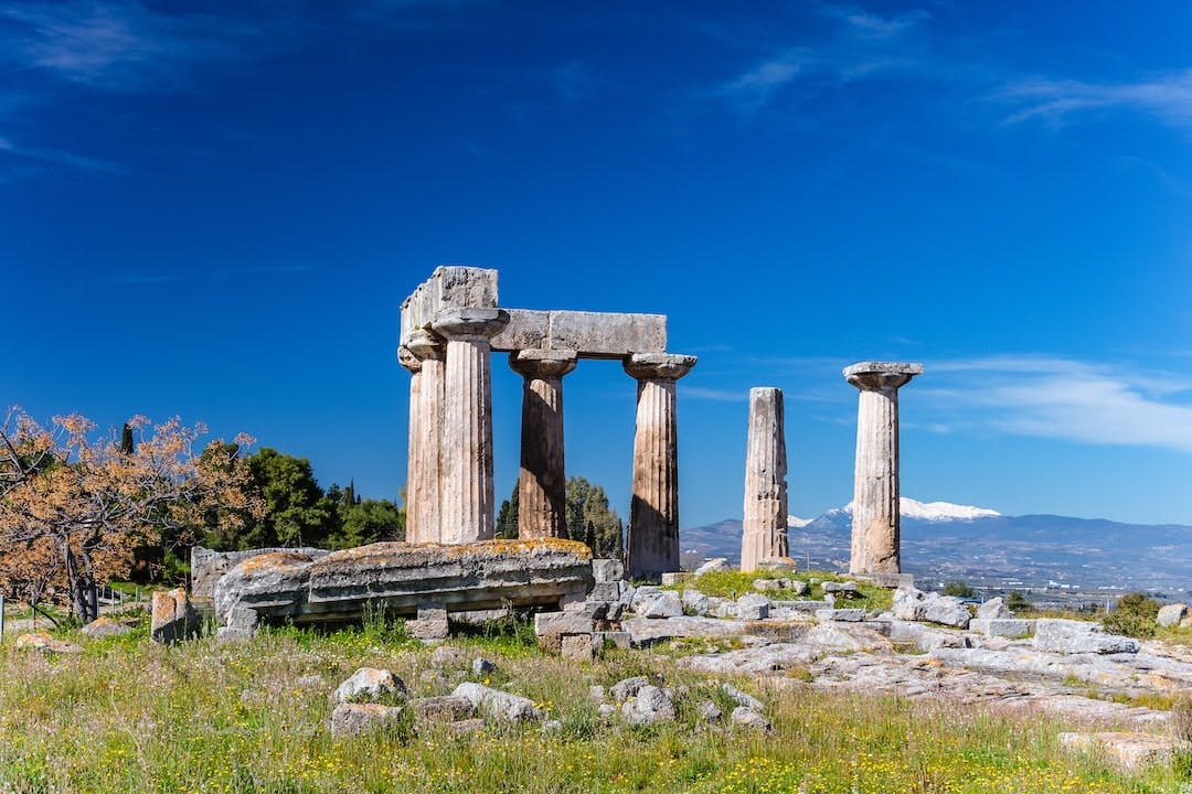 Ruins of Doric Temple of Apollo 6th c BC in Ancient Corinth Greece with blue sky background Ancient Corinth in Greece