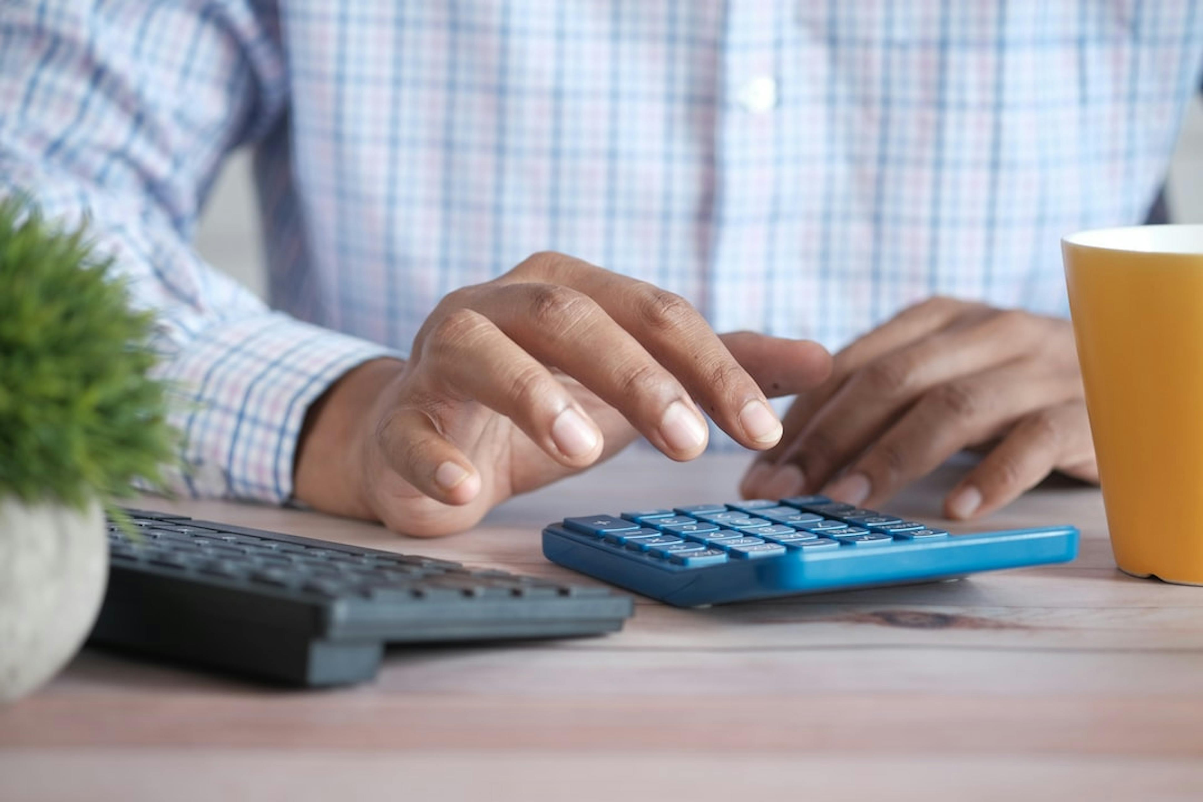 Close up of man hand using calculator