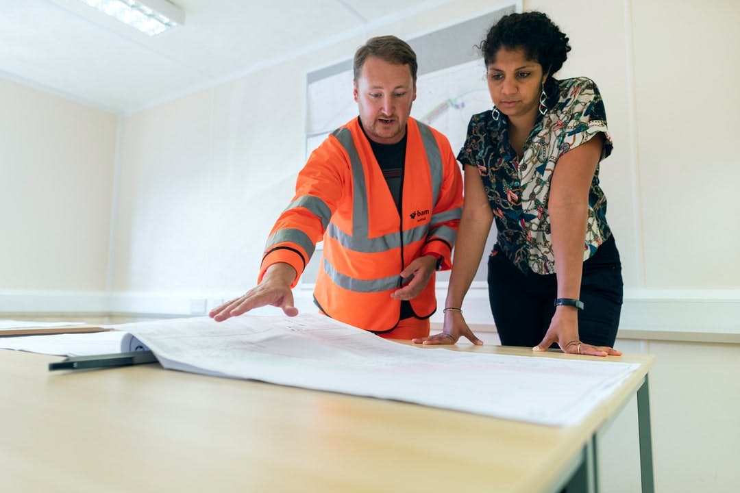Female civil engineer discusses flood risk management with colleague