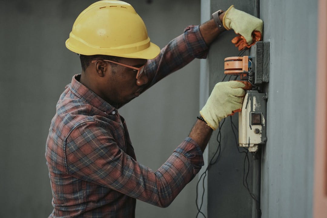 Portrait of a black man architect at a building site looking at camera Confident civil engineering wearing a hardhat and eye goggles Successful mature civil engineer at a construction site with open