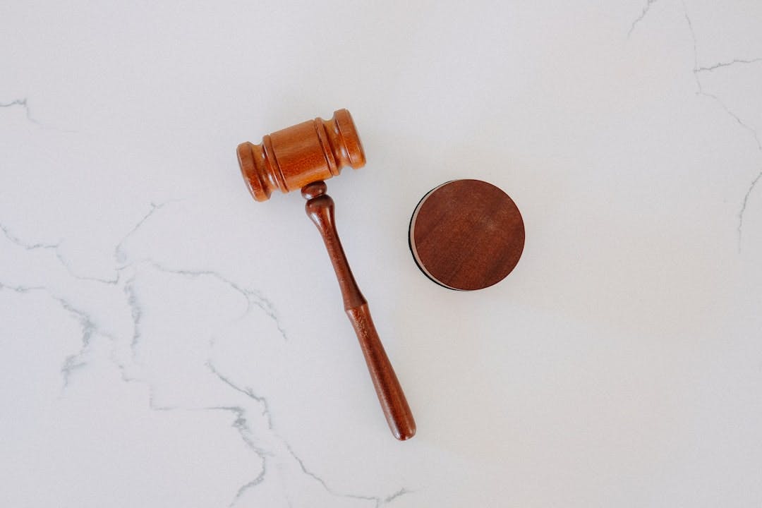 A wooden gavel on a white marble backdrop