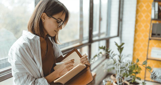 Person journaling by the window