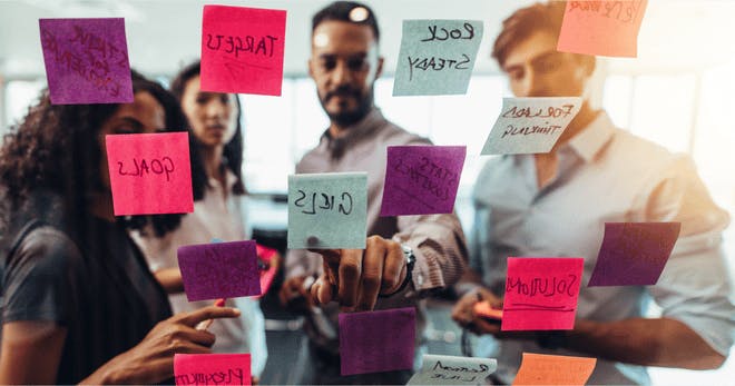 Workers comparing sticky notes